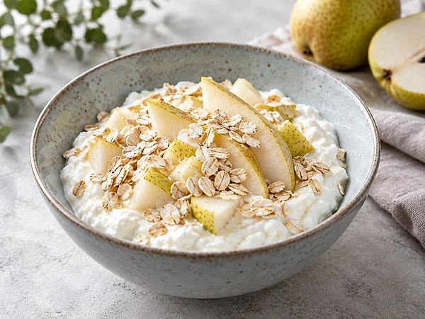 Schale mit cremigem Magerquark, gedünsteten Birnenwürfeln und Haferflocken