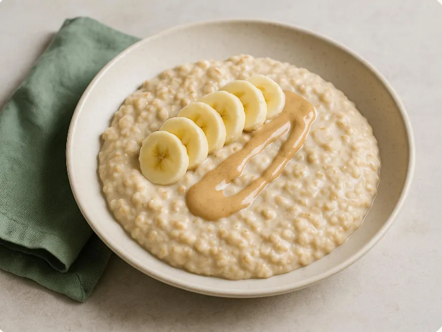 Warmer Haferbrei mit Bananenscheiben und einem Streifen Mandelmus